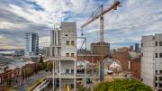 Clouds streak high in the sky above a crane tower on the site of the New Museum 